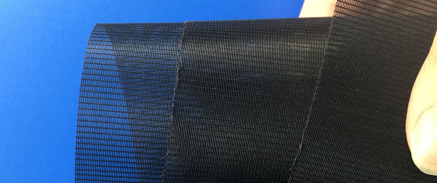 Roll a piece of black anti-pollen screen to show its soft structure.